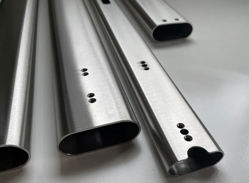 multiple lengths of stainless steel flat-sided oval tube with 5 axis CNC machined cutouts for precision engineering