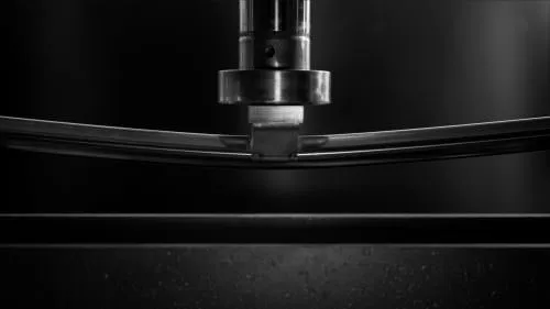 stainless steel mirror polished radius square tubing being stress tested under a hydraulic arm