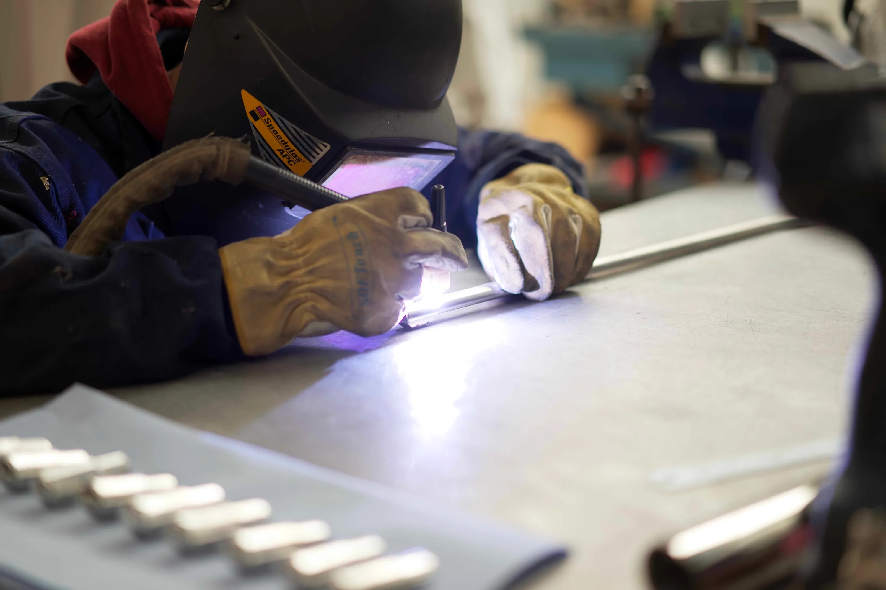 Timeless engineer welding machined components onto a length of D-shaped stainless steel tubing