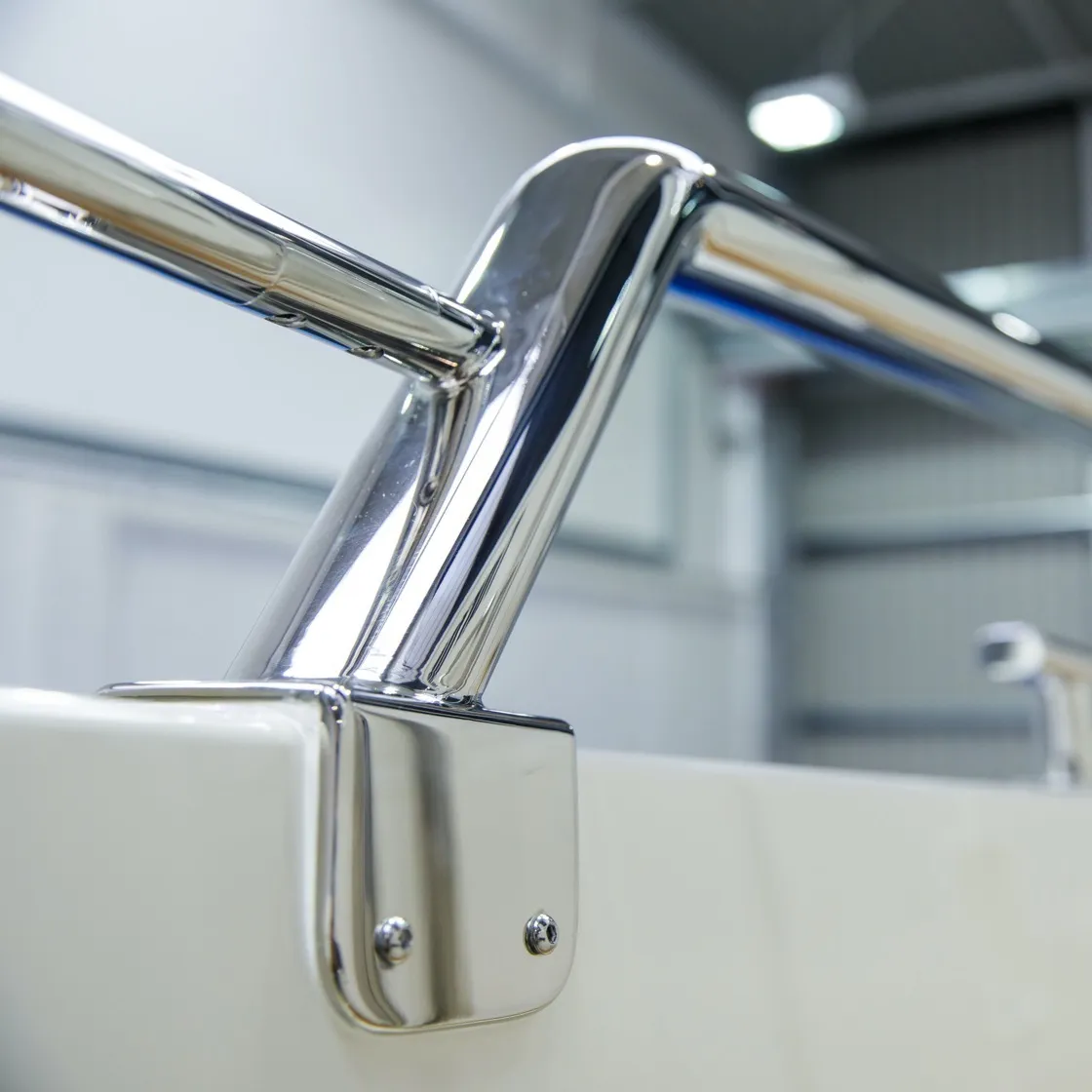 Stainless steel oval shaped marine railing with sloping bend and mounting bracket