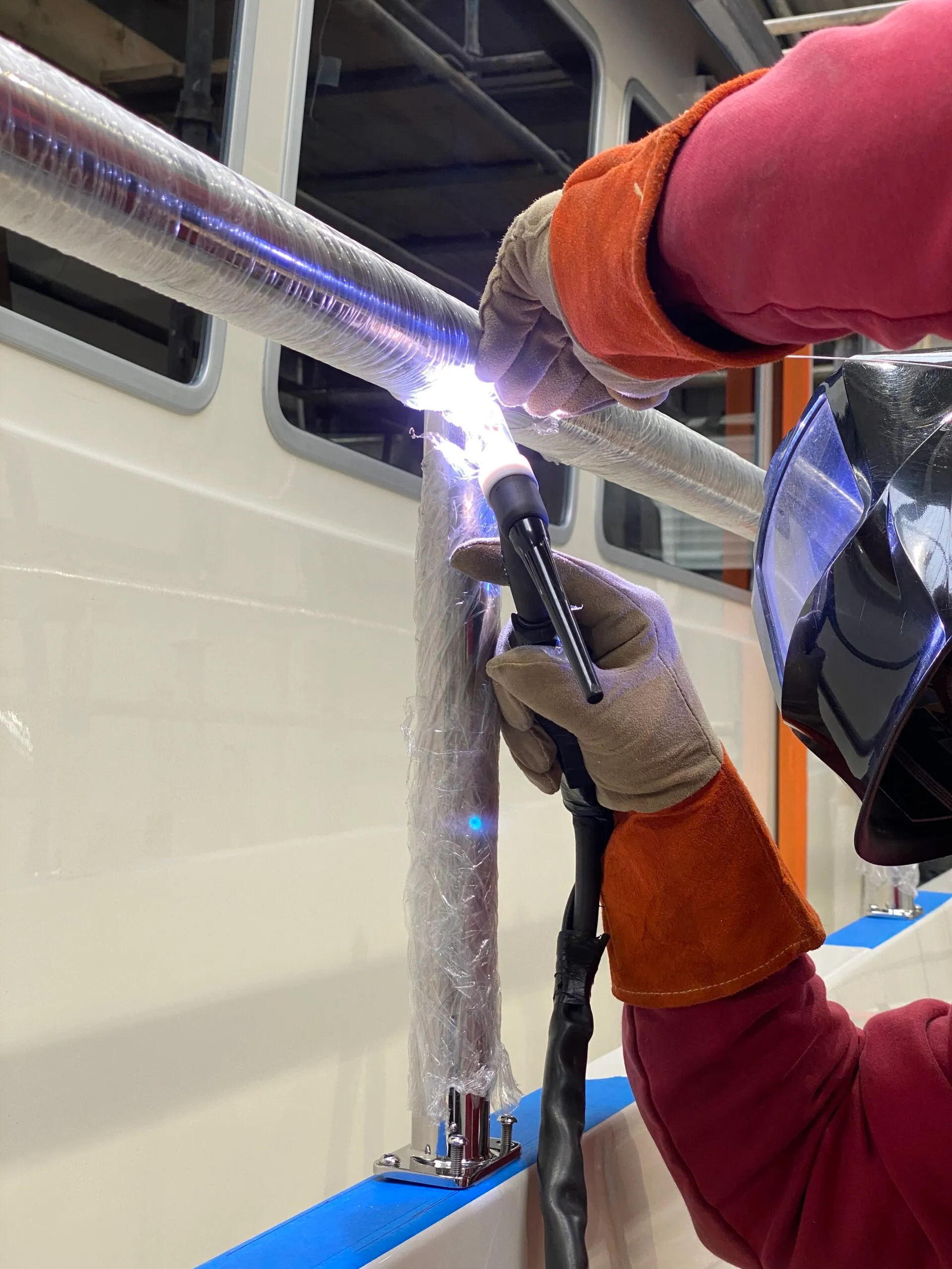 stainless steel oval tubing being welded to a marine rail post for use as a boat rail on a luxury yacht.